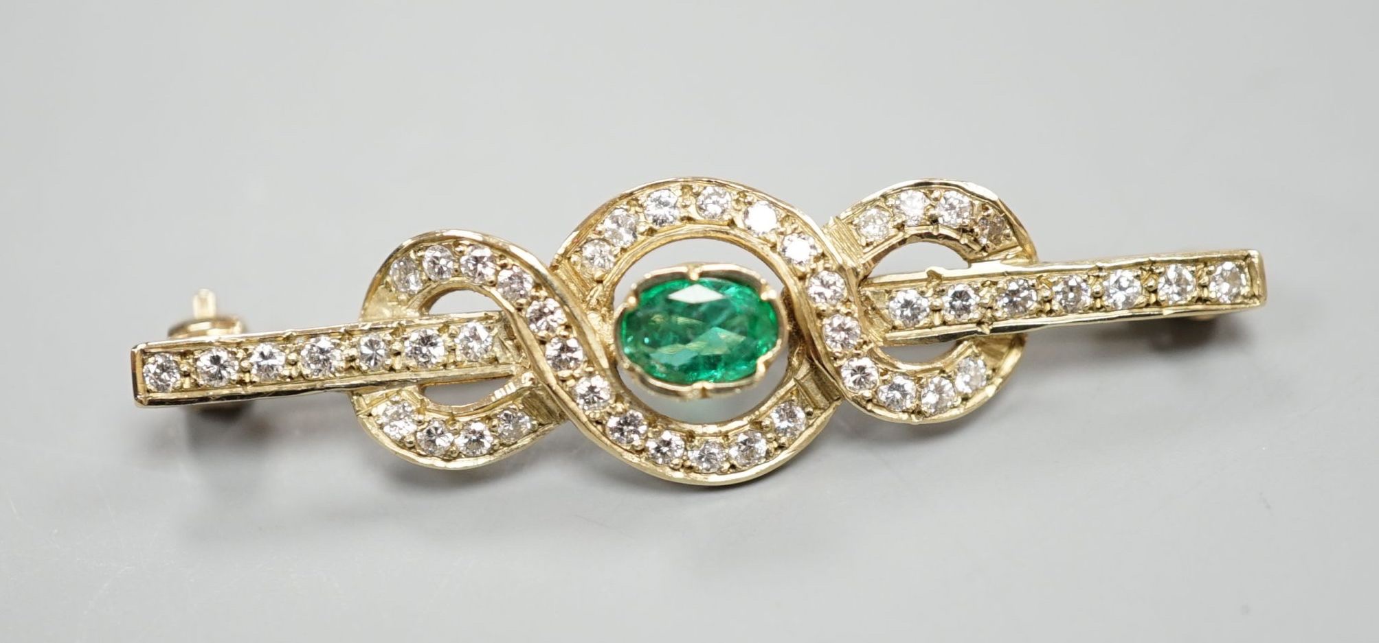 A modern 9ct gold, emerald and diamond cluster set bar brooch, 43mm, gross 3.9 grams.
